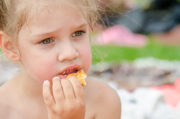 Dívka jíst sušenky a pití šťávy z plastového pohárku jednorázové — Stock fotografie