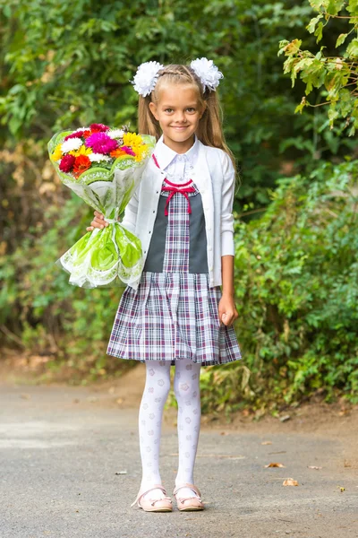 Retrato de uma menina de primeiro grau de sete anos com um buquê de flores — Fotografia de Stock