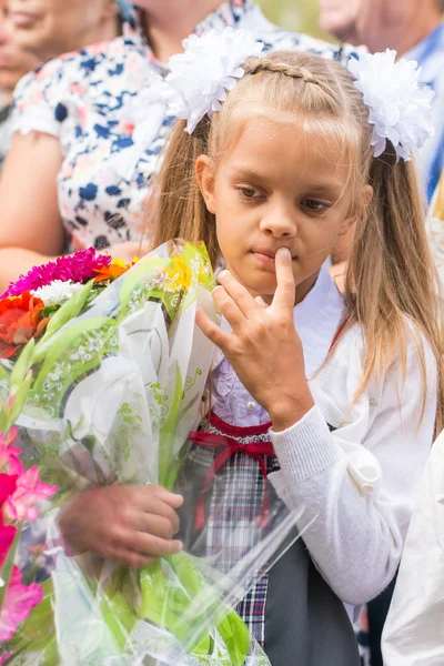 Первый класс на линии первого сентября в мыслях глядя вниз — стоковое фото