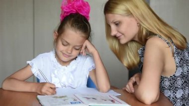 Birinci sınıf öğrencisi ve ödev gülümseyen yapıyor anne çerçeve içine baktı