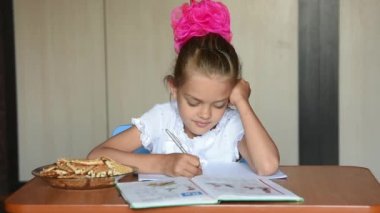 Yedi yaşındaki bir kızın kız öğrenci dağıttı ve çerçeve içine baktı ödev