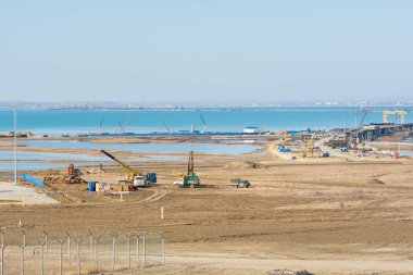 Taman, Rusya - 5 Kasım 2016: Boğaz üzerinde bir köprü inşaatı, arka plandaki Taman Yarımadası kıyı şeridi manzarası, Kasım 2016 itibarıyla