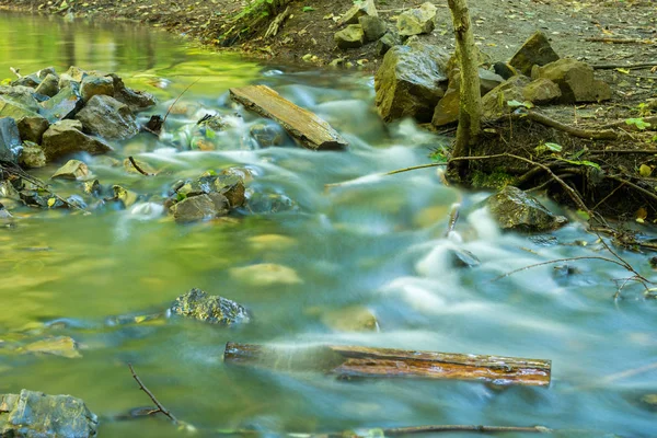 Água corrente de riacho florestal, tomada com uma longa exposição — Fotografia de Stock