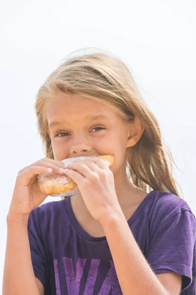 Uma garota com fome com apetite para morder uma torta deliciosa — Fotografia de Stock