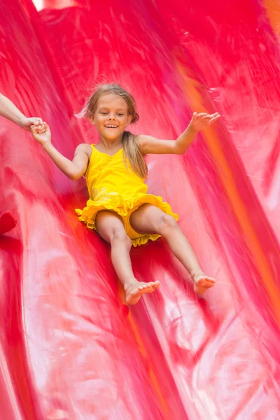 Kind fährt vom hohen aufblasbaren Trampolin — Stockfoto