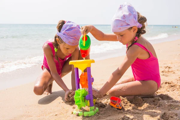 Två barn leker med leksaker i sanden på sea beach — Stockfoto