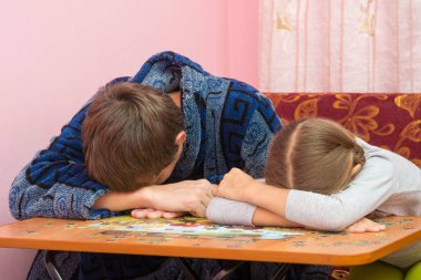 Baba ve kızı bulmaca ların resmini toplarken masada uyuyakaldılar.