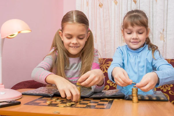 Dvě děti stavět věže mincí — Stock fotografie