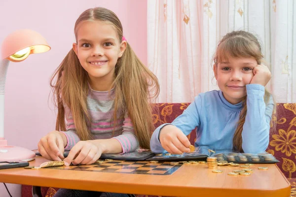 Dvě děti jsou považovány za sbírku mincí v albech — Stock fotografie