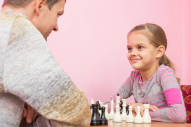 Baba ve kızı mutlu, satranç oynamayı bakıyoruz
