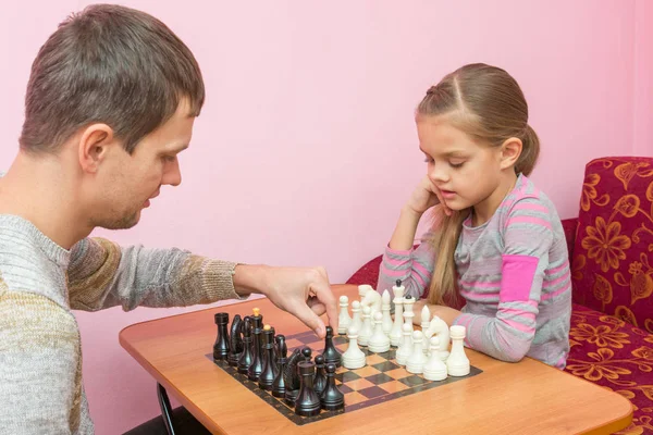 Pai ensina sua filha a fazer os primeiros movimentos no xadrez — Fotografia de Stock