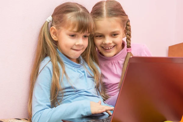 Two girls playing in a notebook fun laughing — Stock Photo, Image