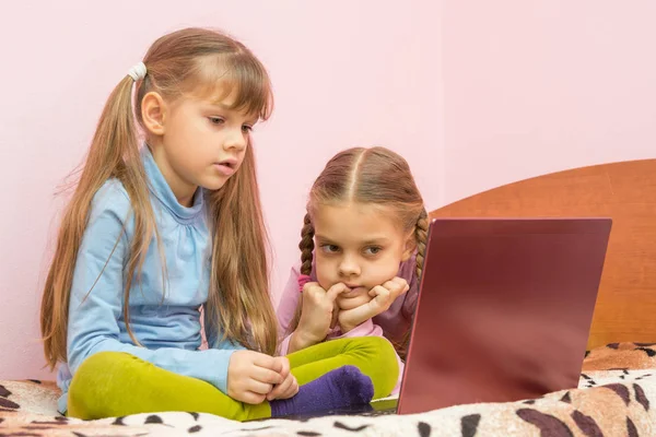 Systrarna är intresserade av att titta på en laptop skärm — Stockfoto