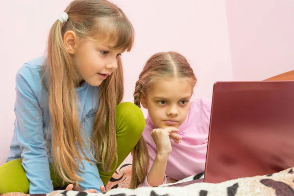 Irmãs olhando para um desenho animado laptop — Fotografia de Stock