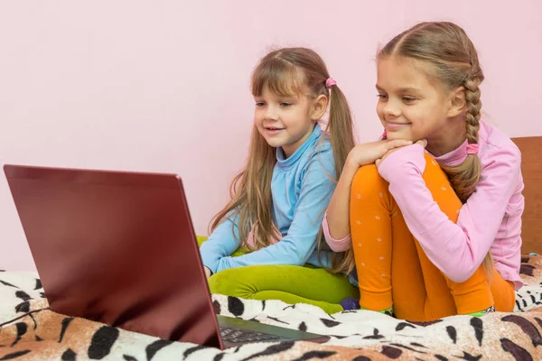 Systrar som tittar på en laptop tecknad — Stockfoto