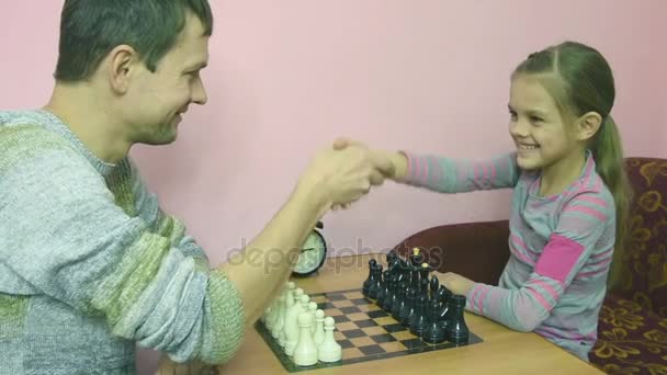 Папа объясняет лучшую дочь, чтобы сделать шаг в игре в шахматы — стоковое видео