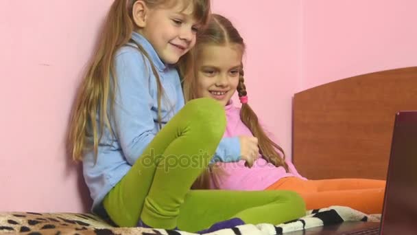 Vicces gyerek ül az ágyon, a laptop képernyője — Stock videók