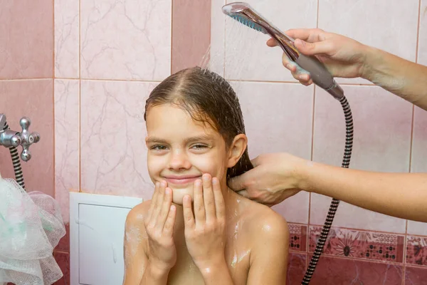 Siete años chica bañarse en un baño bajo la ducha — Foto de Stock