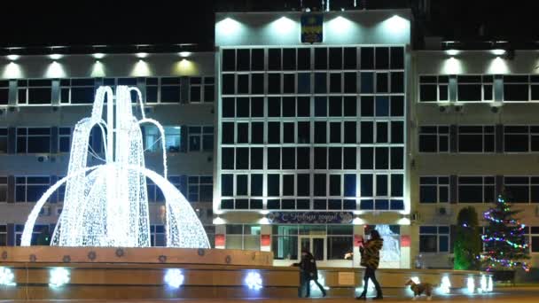 Anapa, Rússia - 7 de janeiro de 2017: Paisagem noturna com vista para a administração da cidade de Anapa resort e as pessoas em frente à fonte, nas férias do Ano Novo — Vídeo de Stock