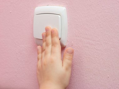 Çocuğun el ışık anahtarı, yakın çekim presler