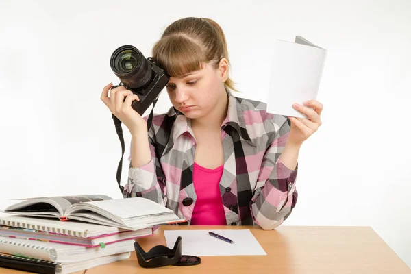 La chica lee los manuales y tutoriales, tratando de aprender a tomar fotos — Foto de Stock