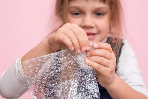 Girl eats balls on the wrapping paper, close-up — Stock Photo, Image