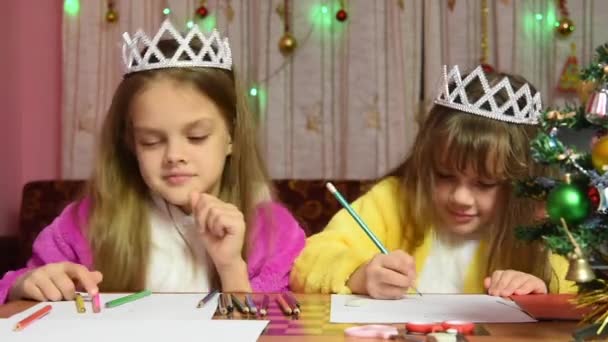 Сестры ругаются и толкают рисунки за столом в рождественской обстановке — стоковое видео