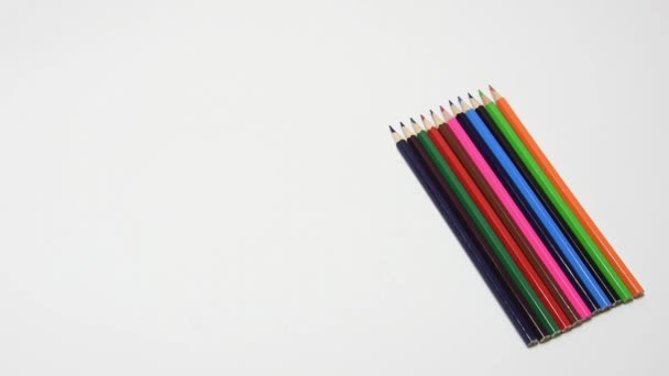 Mettez à la main un crayon jaune sur un ensemble de crayons, gros plan, fond blanc — Video