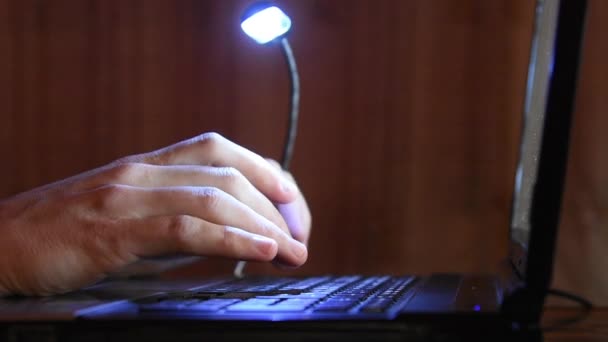 Tecleo a mano en el teclado de la computadora, el teclado está iluminado desde arriba de la lámpara led — Vídeos de Stock