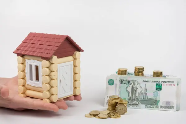 Las manos de la casa de juguete de pie cerca del dinero es comprar vivienda — Foto de Stock