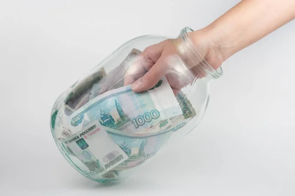 Рука виймає з три літровий скляні банки тисяч російських рублях Ліцензійні Стокові Фото