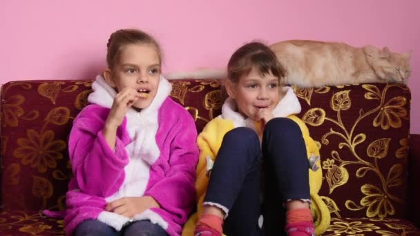 La gioia dei bambini che succhiano lecca-lecca e guardano la TV — Video Stock