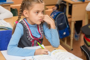 Kız kız öğrenci okul masa başında bir bölümünü okulda oturur