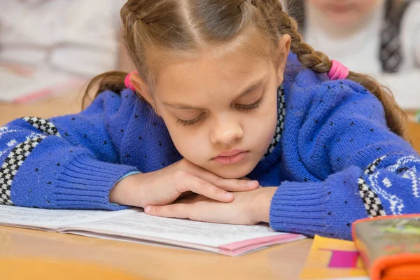 Erstklässler lesen den Text im Buch mit dem Kopf in der Hand — Stockfoto