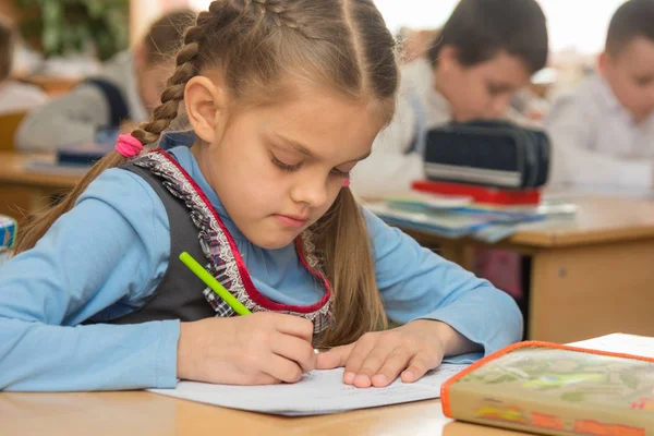 Primeiro graduador na escrita da classe no caderno — Fotografia de Stock