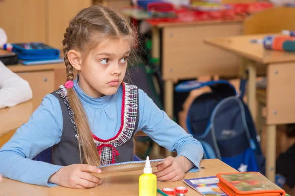 Chica en la escuela a la clase de trabajo no ha entendido la tarea y con un desconcertado mirando al maestro — Foto de Stock