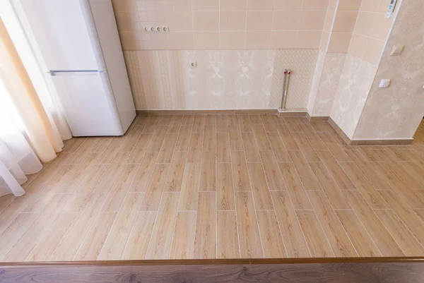 Piso de zoneamento no interior, azulejos cerâmicos da cozinha com fronteira com piso laminado na sala de estar — Fotografia de Stock