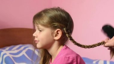 Anne kızı helezon örgülü ve onu yanağından öptü