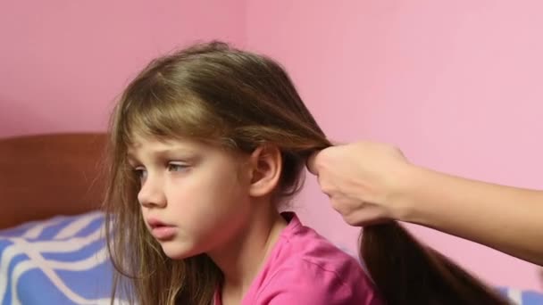 Μητέρα χτενίζει τα μακριά μαλλιά κορίτσια και τους πλεξούδα σε μια Κοτσίδα — Αρχείο Βίντεο