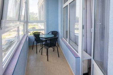 Bir masa ve çok öykülü bir apartman dairesinde balkonda üç sandalyeler