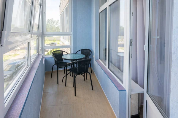 Stůl a tři židle na balkoně v bytě vícepodlažního bytového domu — Stock fotografie