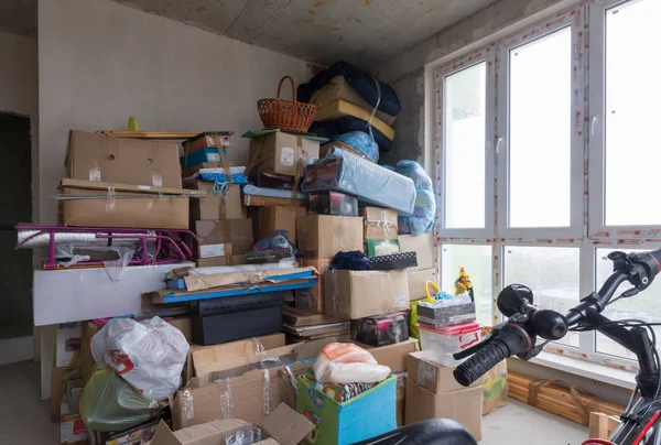 Déménager dans l'appartement un nouveau bâtiment, des boîtes et des objets personnels sur fond de murs en béton — Photo