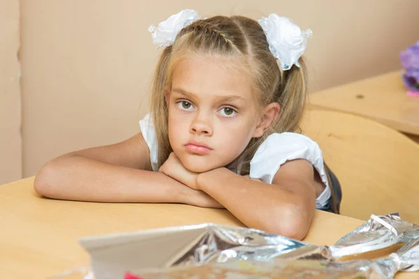 Uma menina triste em sua mesa na lição do primeiro de setembro — Fotografia de Stock