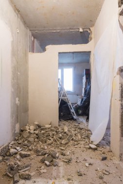 Dairedeki duvarları sökmek, arka planda eşyalarıolan kutular var.