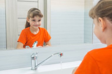 Onun yüzünü yıkama 7 yaş kız kendini Aynaya bakar