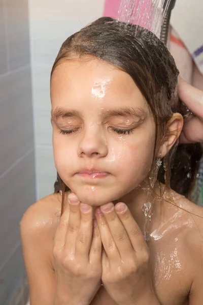 Rosto da menina derramado pela mãe do chuveiro, close-up — Fotografia de Stock
