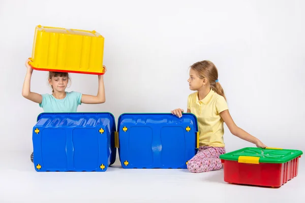 Two girls play with large plastic boxes — Stock Photo, Image