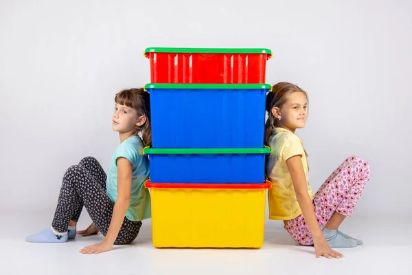 Duas meninas de lados diferentes apoiaram suas costas em caixas de plástico — Fotografia de Stock
