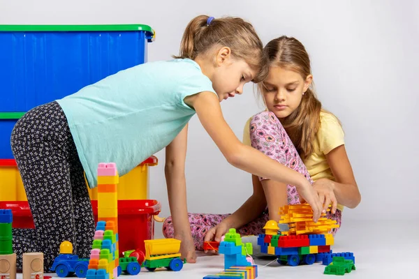 Two girls collect figures from the designer — Stock Photo, Image