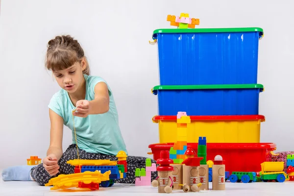 Girl alone plays constructor and other toys — Stock Photo, Image